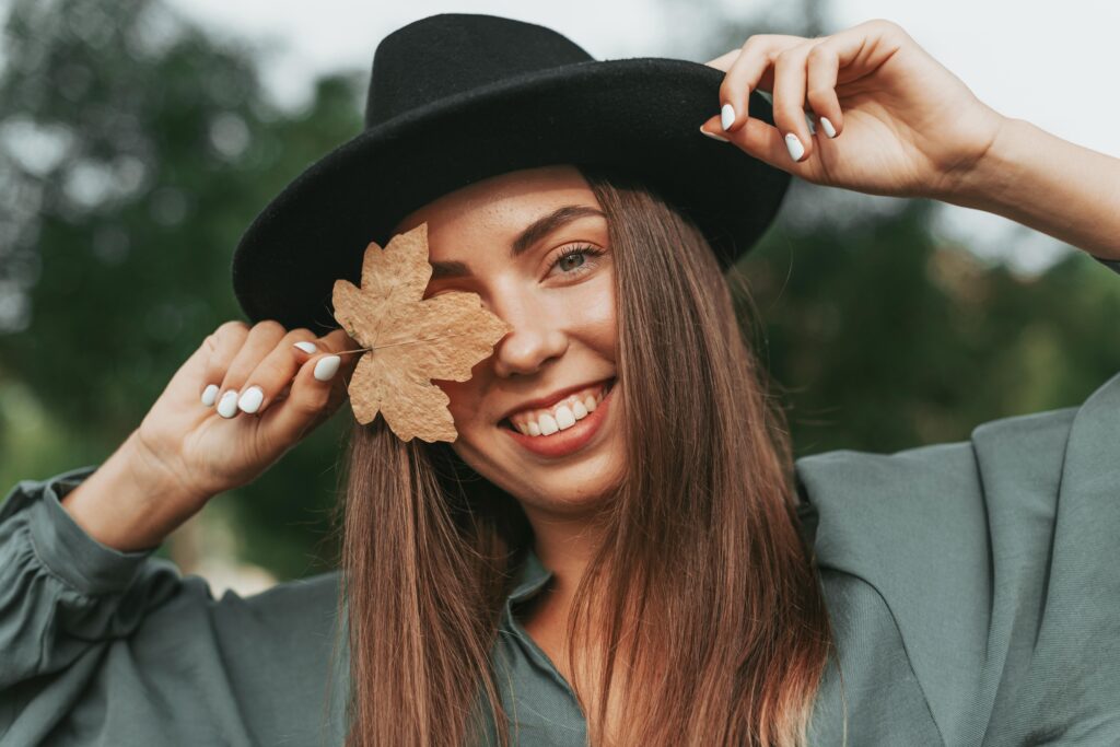 mujer joven con hojas seca de otoño